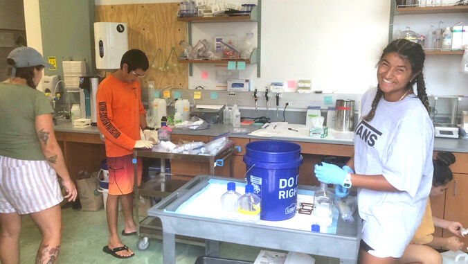 person in a lab with other researchers