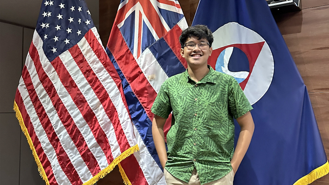 person headshot with flags behind