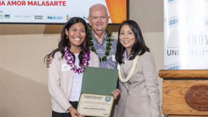 three people smiling and holding a certificate