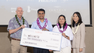 four people standing and holding a check
