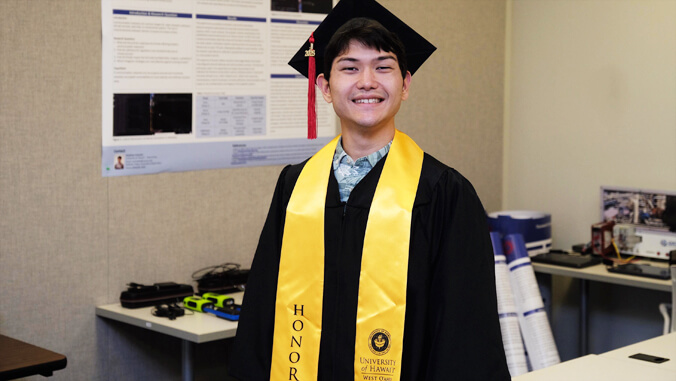 Graduate in cap and gown with honors sash