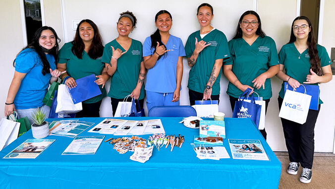 group of vet tech students standing behind information table